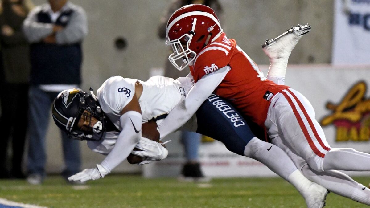 St. John Bosco receiver Jake Bailey falls into the end zone on touchdown pass as Mater Dei's Joshua Hunter defends in the first half at Santa Ana Stadium on Saturday.