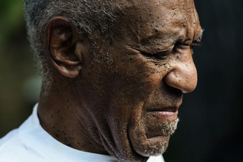 Bill Cosby listens to members of his team speak during a news conference outside his home in Elkins Park, Pa., Wednesday, June 30, 2021, after being released from prison. Pennsylvania's highest court has overturned comedian Cosby's sex assault conviction. The court said Wednesday, that they found an agreement with a previous prosecutor prevented him from being charged in the case. The 83-year-old Cosby had served more than two years at the state prison near Philadelphia and was released. (AP Photo/Matt Rourke)