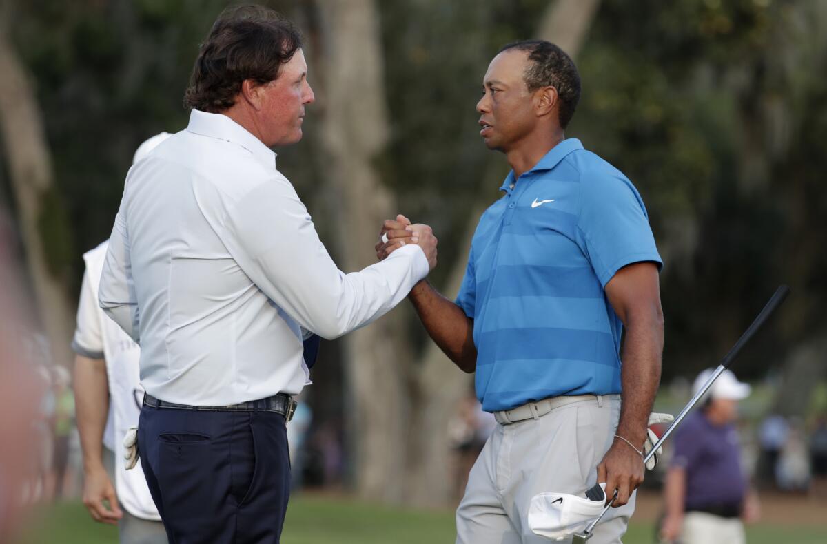 Phil Mickelson and Tiger Woods shake hands after the first round of the Players Championship in 2018