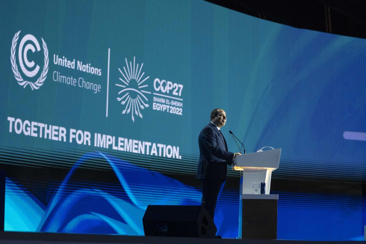 A man onstage behind a lectern.