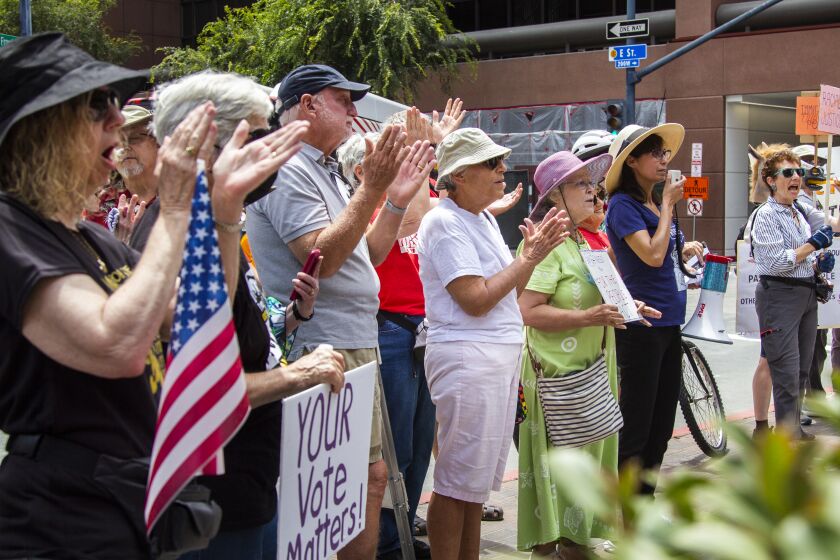 San Diego, CA - July 08: Protesters applaud at the San Diego Indivisible Groups protest to Sen. Feinstein's refusal to stand up to end the filibuster at the Edward J. Schwartz federal building in San Diego, CA. (Brittany Cruz-Fejeran / The San Diego Union-Tribune)