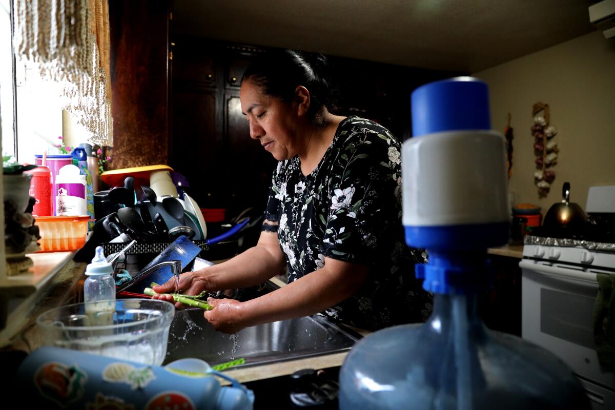 Carolina Ledesma García washes asparagus at her house, where she relies on water delivered to a household tank. 