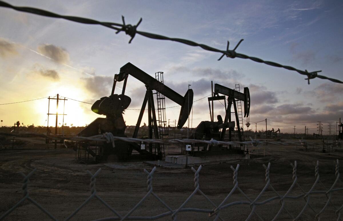 The sun sets beyond pumpjacks operating at the Inglewood oil fields in Baldwin Hills.