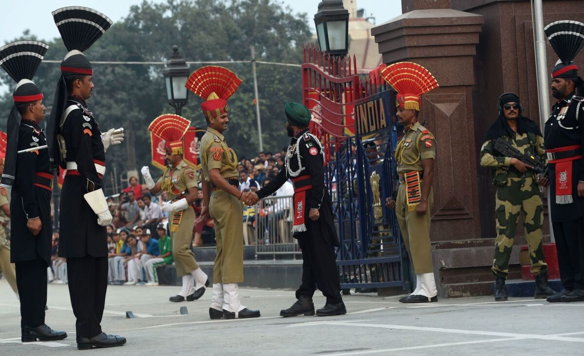 A Pakistani Ranger, right, and an Indian Border Security Force soldier shake hands during a flag ceremony at the India-Pakistan Wagah Border Post on Oct. 20, 2016.