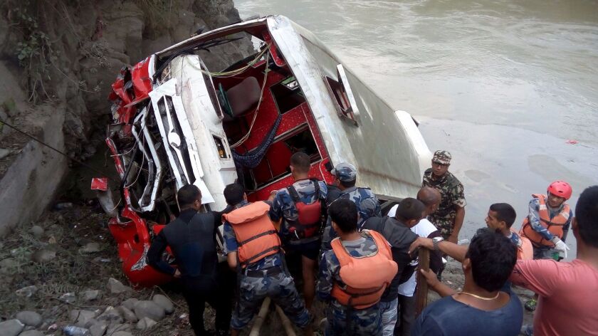 Nepali rescuers work at the scene of a bus crash about 50 miles east of Kathmandu.