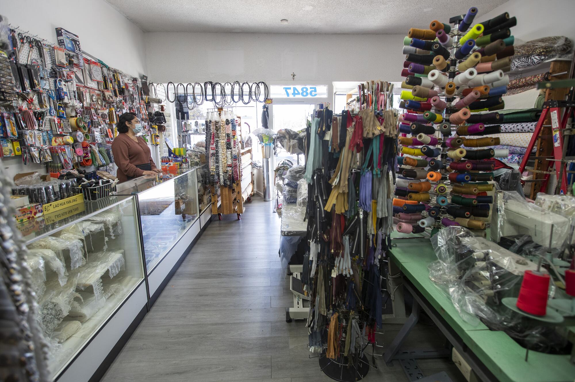 Isabel Tellez, 49, daughter of the owner,  behind the counter of Abuelitas Sewing Machine & Repair 