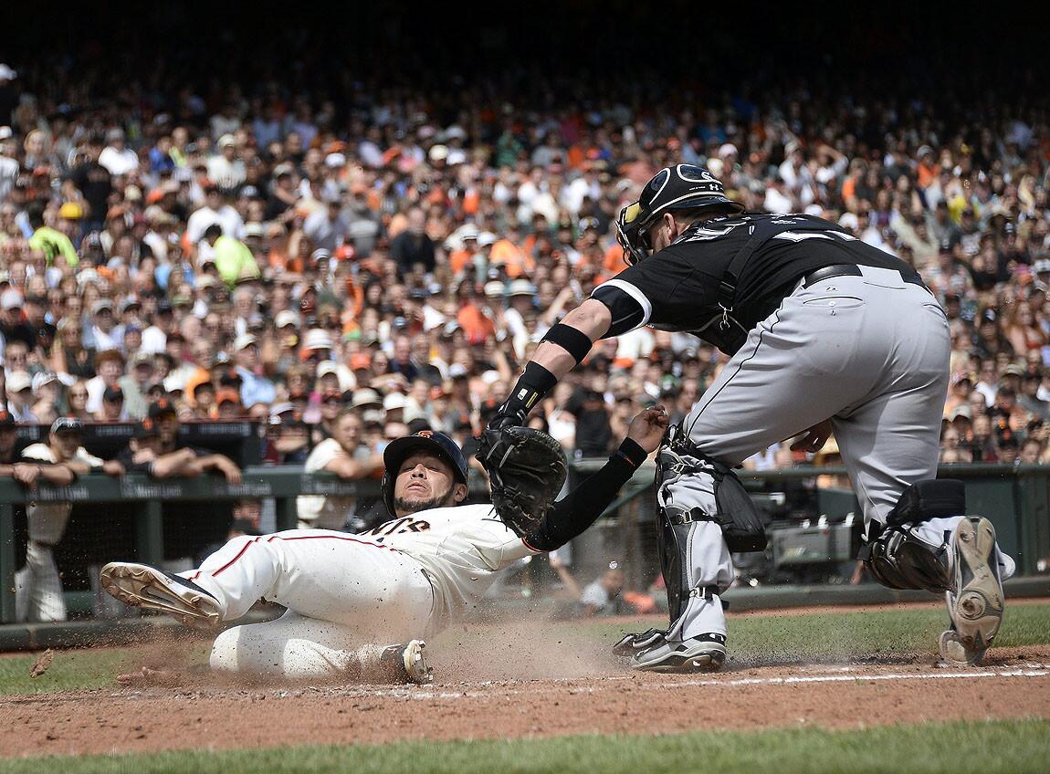 San Francisco Giants pinch-runner Gregor Blanco beats Tyler Flowers' tag to score a run in the seventh inning.