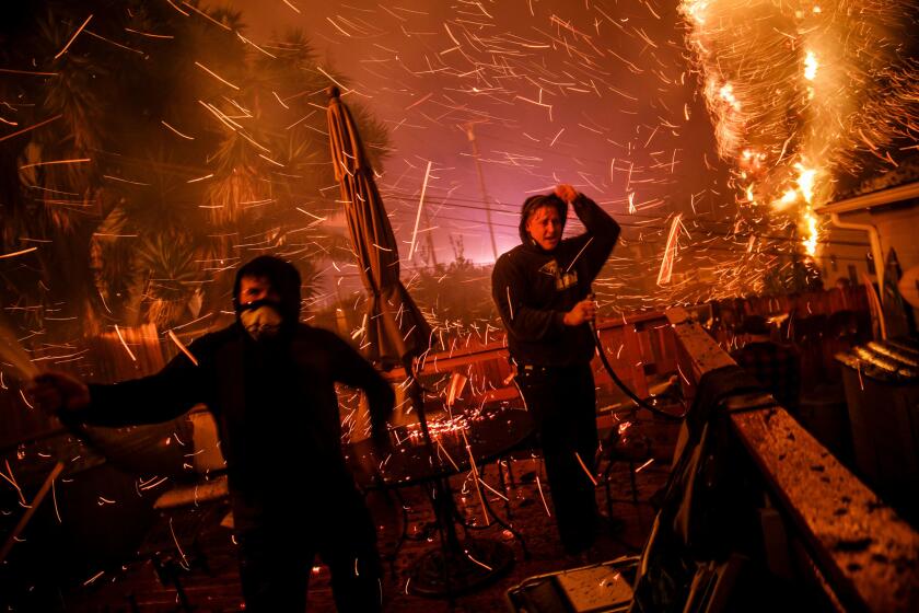 John Bain and Brandon Baker try to stop a fire from burning a stranger's home in Ventura.