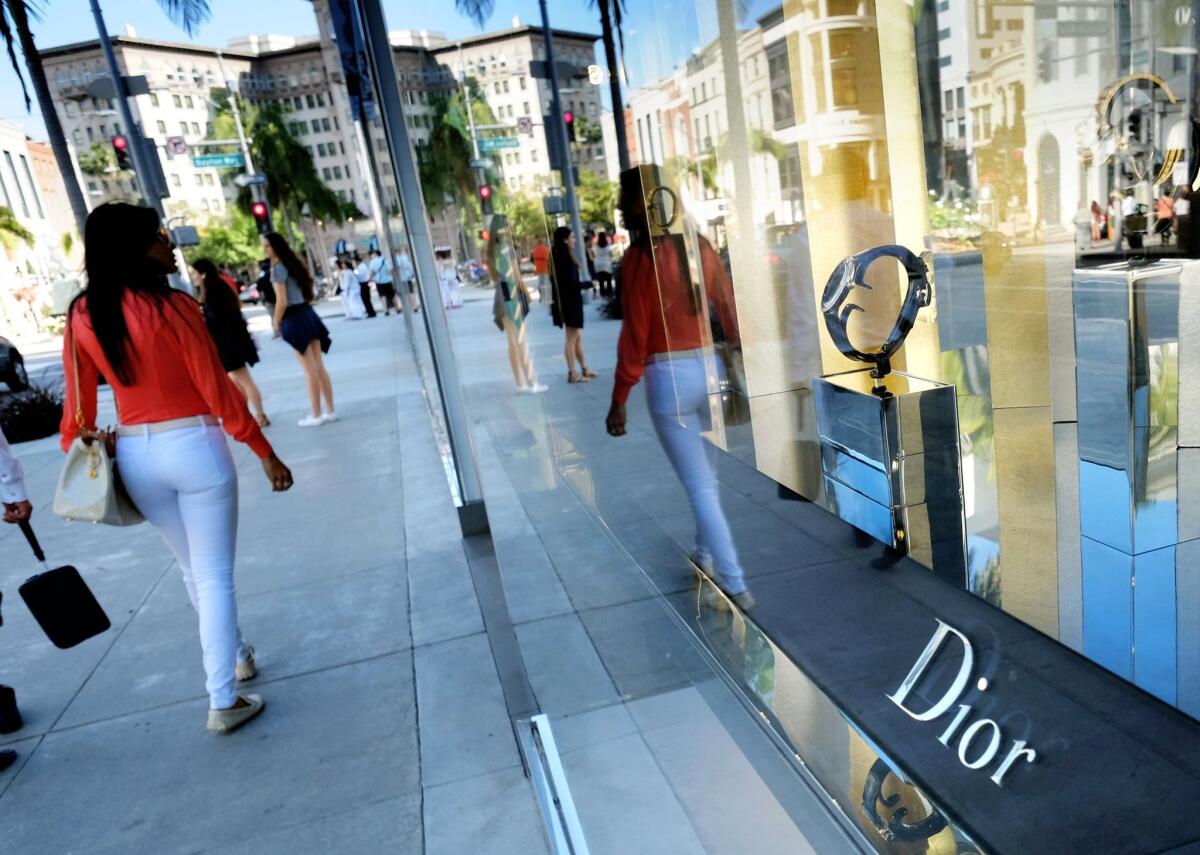 Shoppers walk past a Dior shop on Rodeo Drive in Beverly Hills on April 2.
