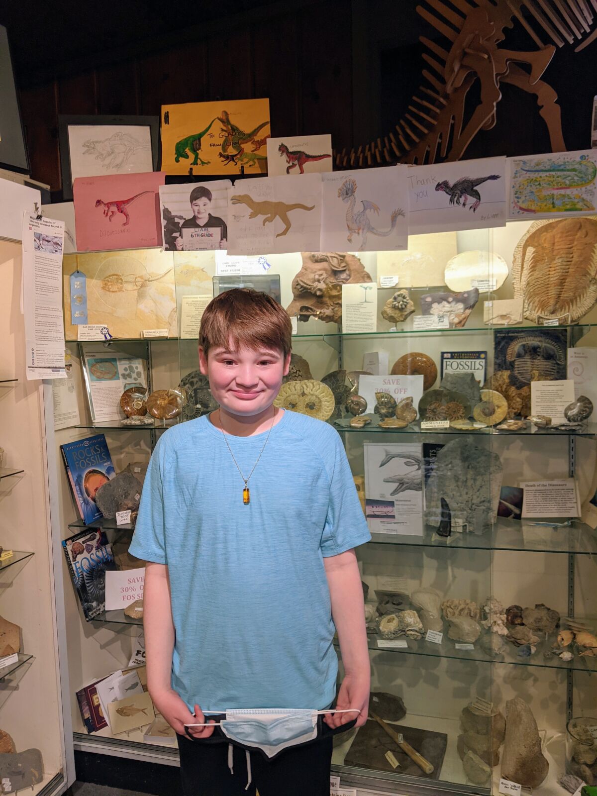 Liam Wrona with his artwork on display at Dinosaur Gallery.