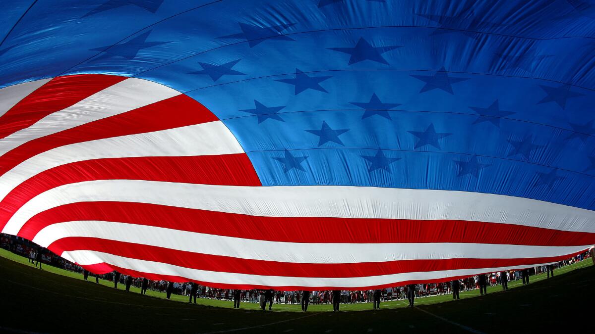 A large American flag covers the field before a game between the Arizona Cardinals and New York Giants in Tempe, Ariz., in November 2004.