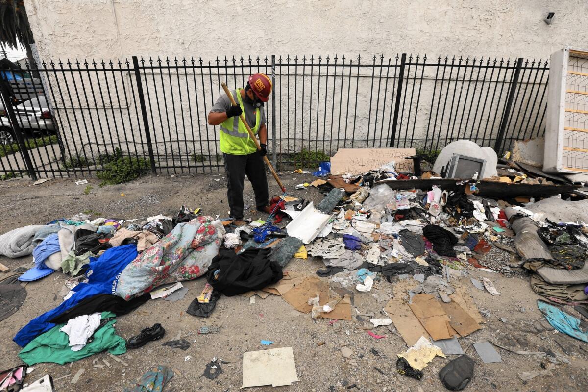 A city sanitation crew cleans illegally dumped trash in South L.A. Many poor areas of L.A. saw requests for cleanup service answered at dramatically lower rates than more affluent neighborhoods.