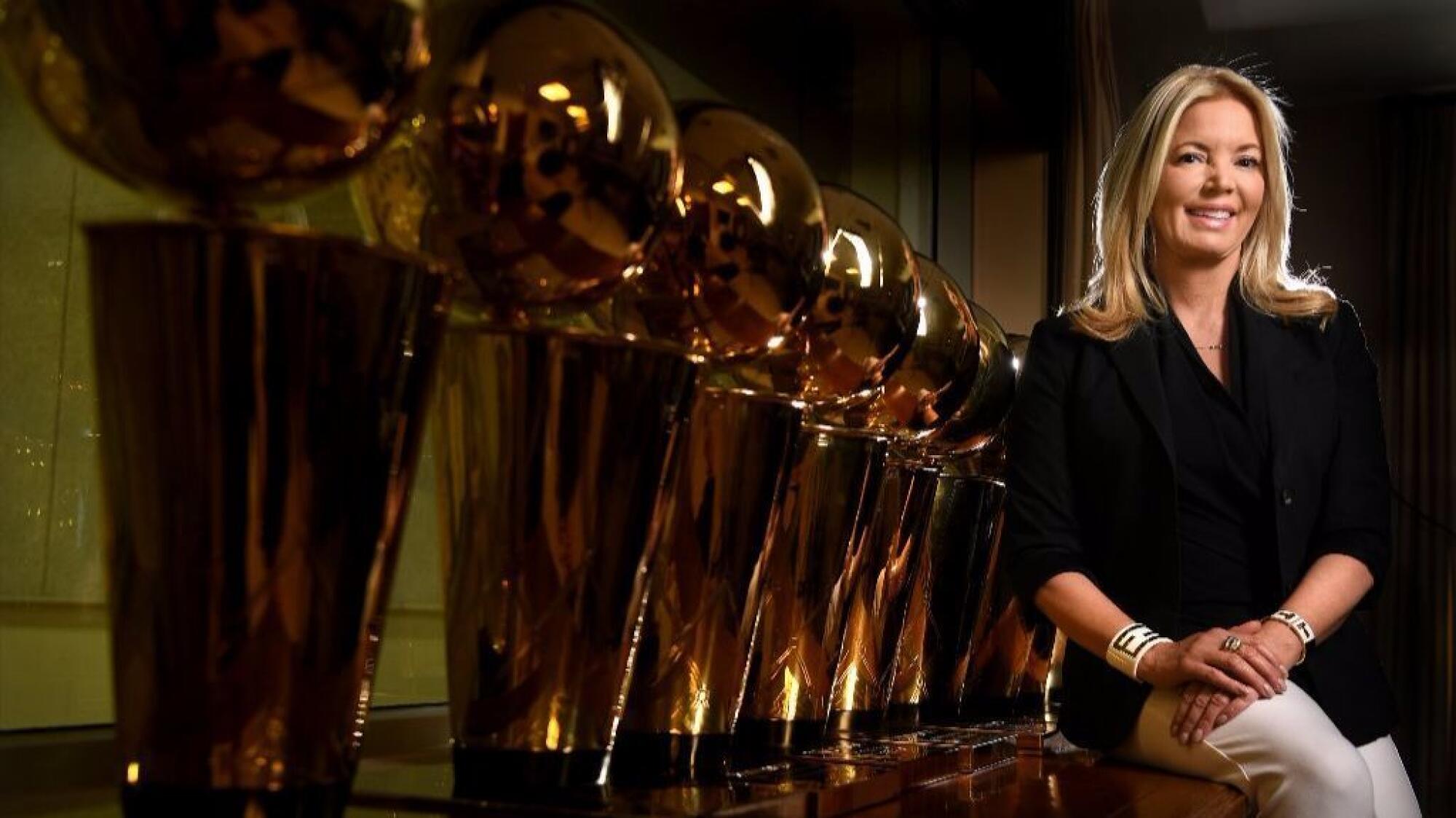 Jeanie Buss sits next to NBA championship trophies in her El Segundo office.