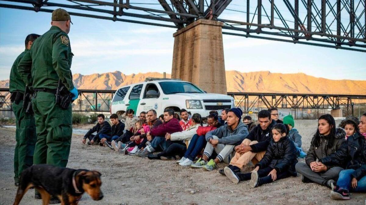 A group of about 30 Brazilian migrants who just crossed the border sit on the ground near U.S. Border Patrol agents on the U.S.-Mexico border in Sunland Park, N.M.