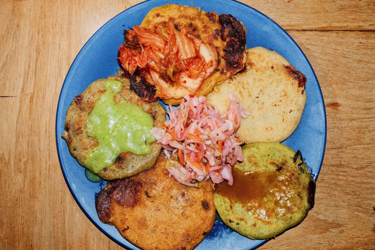 An overhead photo of five pupusas on a blue plate at Walking Spanish inside Las Perlas.