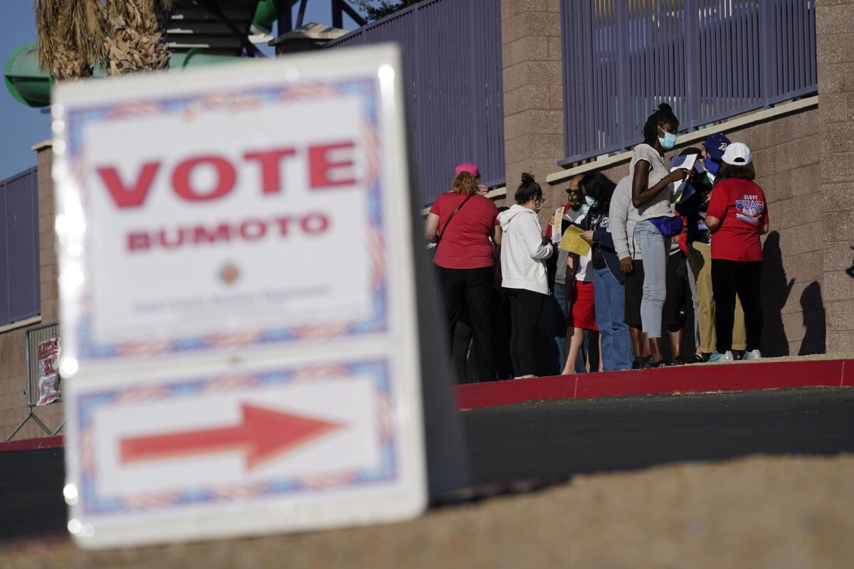 FILE - People wait in line to vote at a polling place on Election Day, Nov. 3, 2020, in Las Vegas. Ballots will be counted after the poll close Tuesday, Nov. 8, 2022, despite the efforts of candidates loyal to former President Donald Trump to spread doubt about the outcome of the 2020 election and these 2022 midterms. The Associated Press collects all the vote data and declares the winners. It also outlines how the voting process work in a series of explanatory stories you can explore here. (AP Photo/John Locher, File)