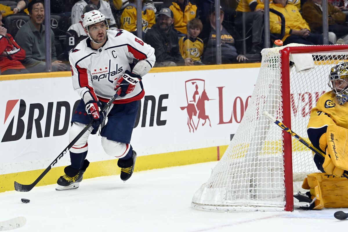 Washington Capitals left wing Alex Ovechkin (8) moves the puck behind the net during the first period of the team's NHL hockey game against the Nashville Predators, Tuesday, Feb. 15, 2022, in Nashville, Tenn. (AP Photo/Mark Zaleski)