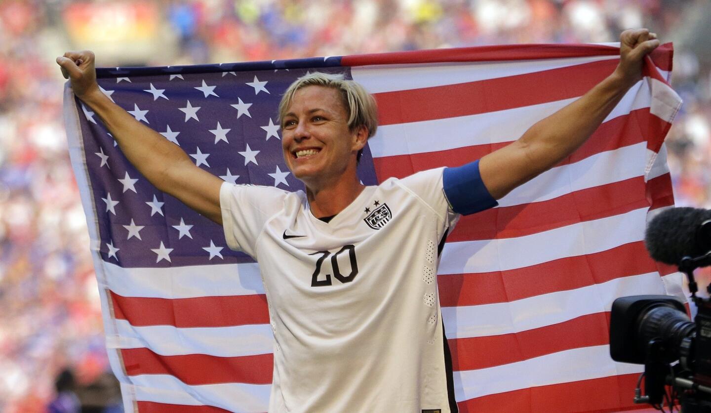 FILE - In this July 5, 2015, file photo, United States' Abby Wambach holds an American flag after the U.S. beat Japan 5-2 in the FIFA Women's World Cup soccer championship in Vancouver, British Columbia, Canada. Wambach, the leading career scorer, male or female, in international soccer, announced her retirement from soccer on Tuesday, Oct. 27, 2015, shortly after the U.S. national team celebrated its Women's World Cup victory at the White House. (AP Photo/Elaine Thompson, File_