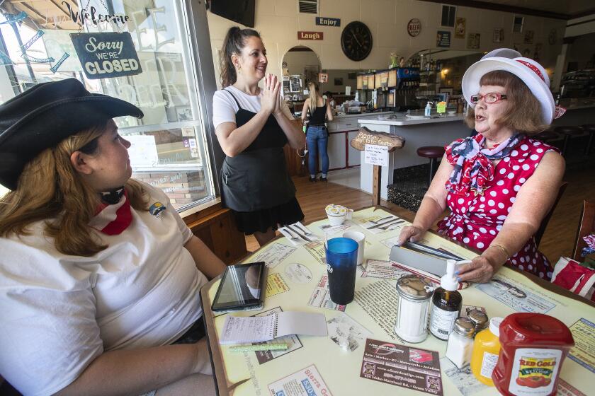 GRASS VALLEY, CA-MAY 22, 2020: Lisa Shippers, center, owner of Old Town Cafe in Grass Valley, talks with Grass Valley residents Sabrina Hocking, 31, left, and her mother, Judith Hocking, 63, as they wait for their breakfast to arrive. The cafe fully re-opened on May 13, previously doing curbside only pick-up due to the coronavirus outbreak. (Mel Melcon/Los Angeles Times)