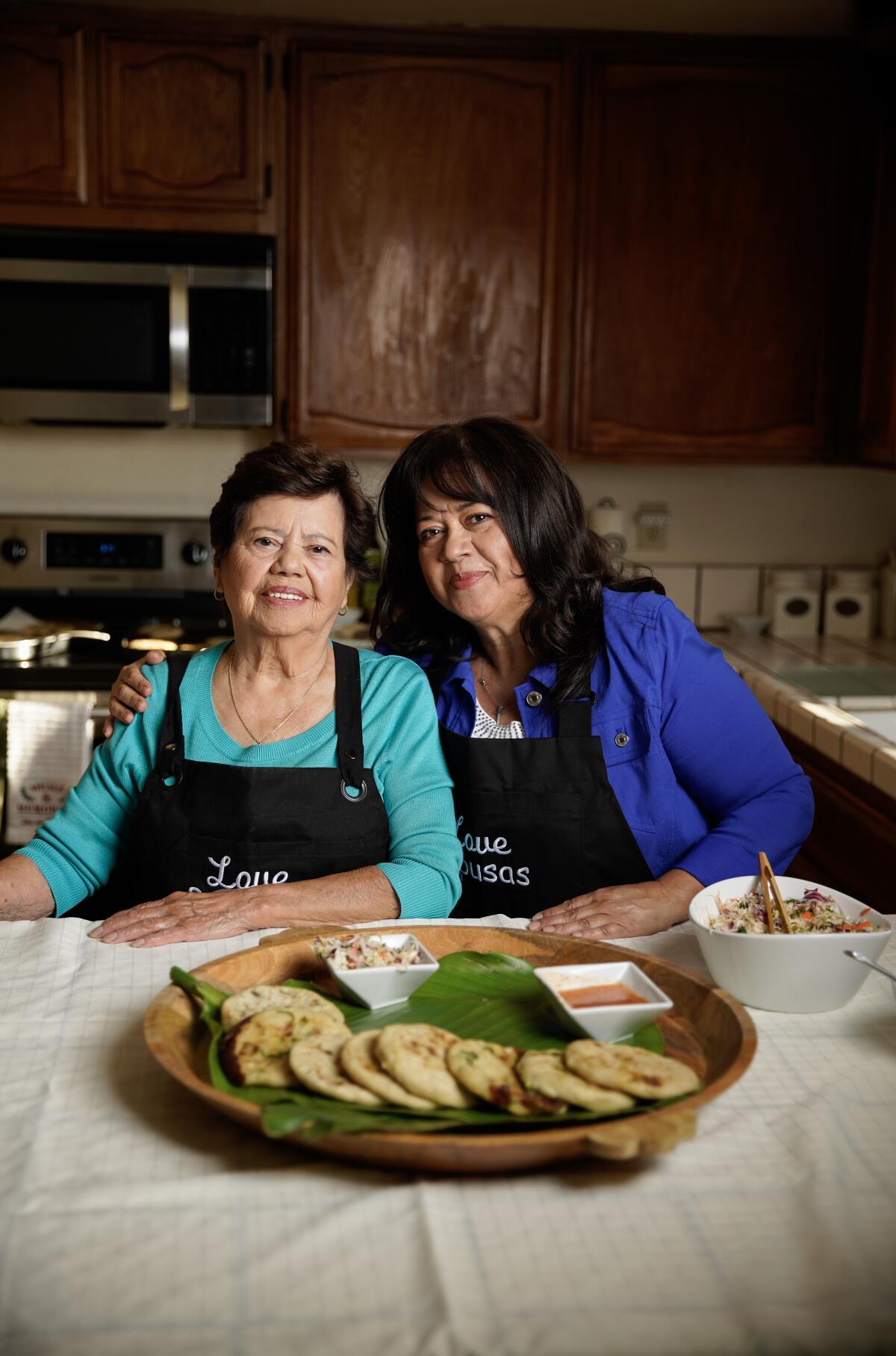 Yanira Majano and her 85-year-old mother, Martha Martinez, look over the pupusas they made using old family recipes.