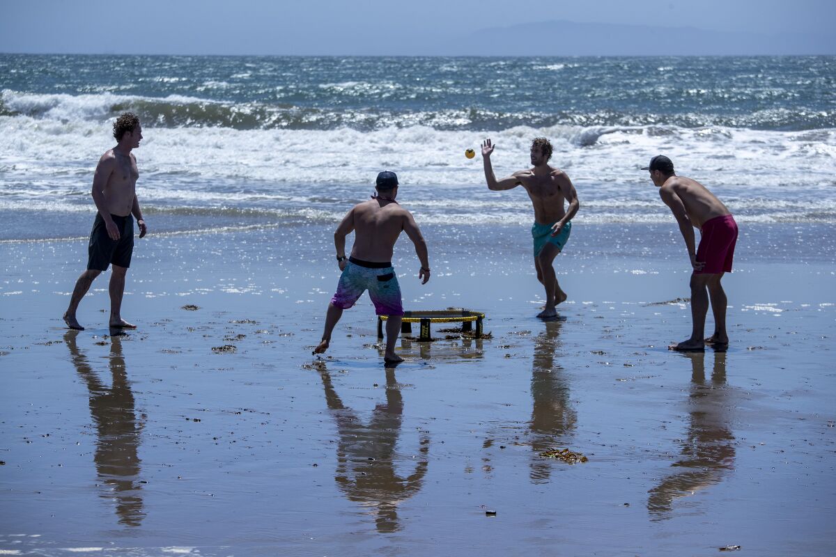 Friends play spikeball, a game perfect for social distancing, on an open but restricted San Buenaventura State Beach on Saturday in Ventura, Calif.