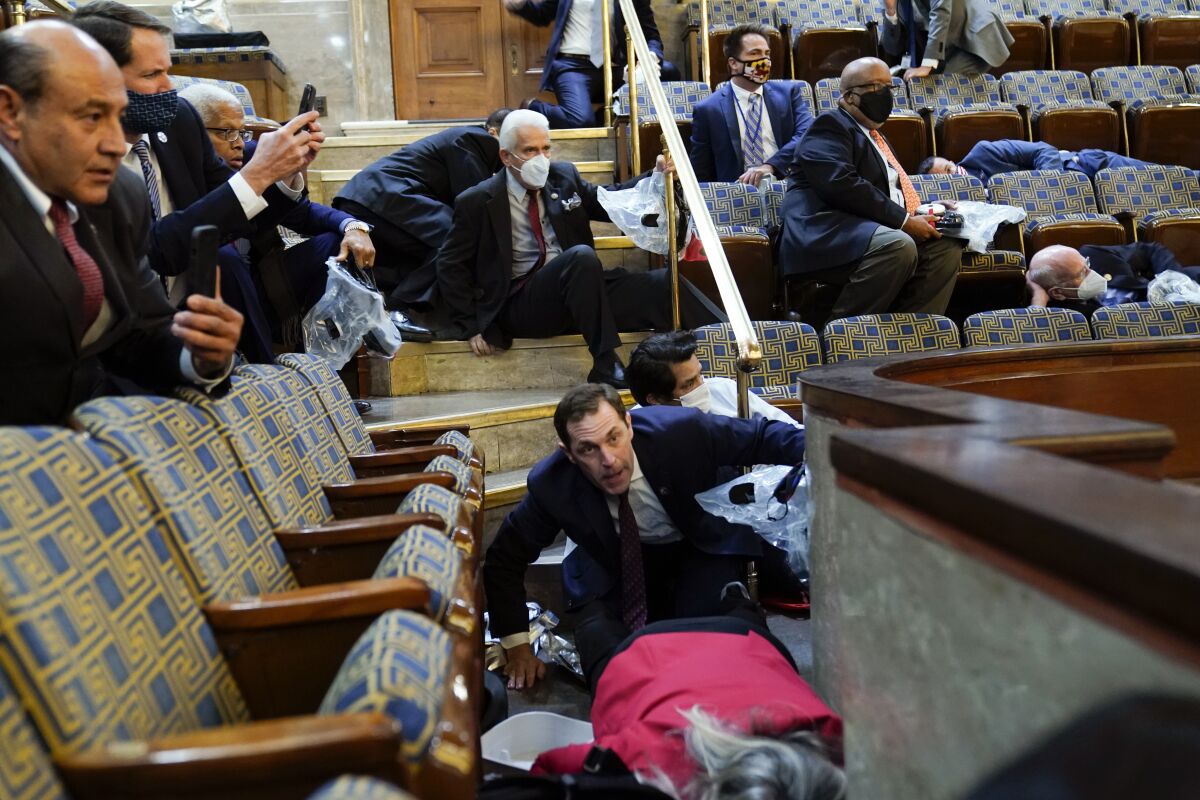 FILE - Members of Congress shelter in the House gallery as rioters try to break into the House Chamber at the U.S. Capitol on Jan. 6, 2021, in Washington. (AP Photo/Andrew Harnik, File)