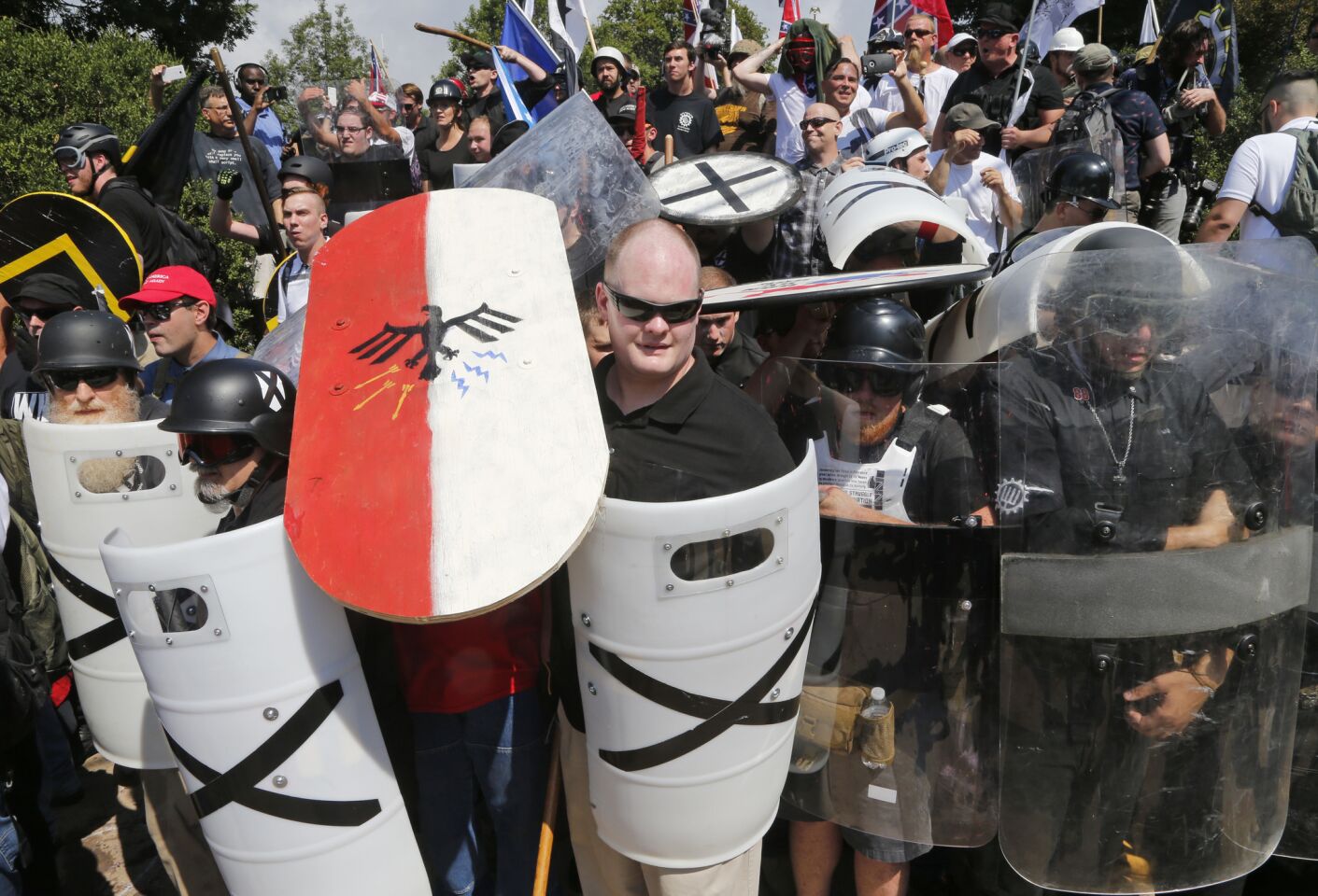 White nationalist demonstrators use shields as they guard the entrance to Lee Park in Charlottesville, Va.