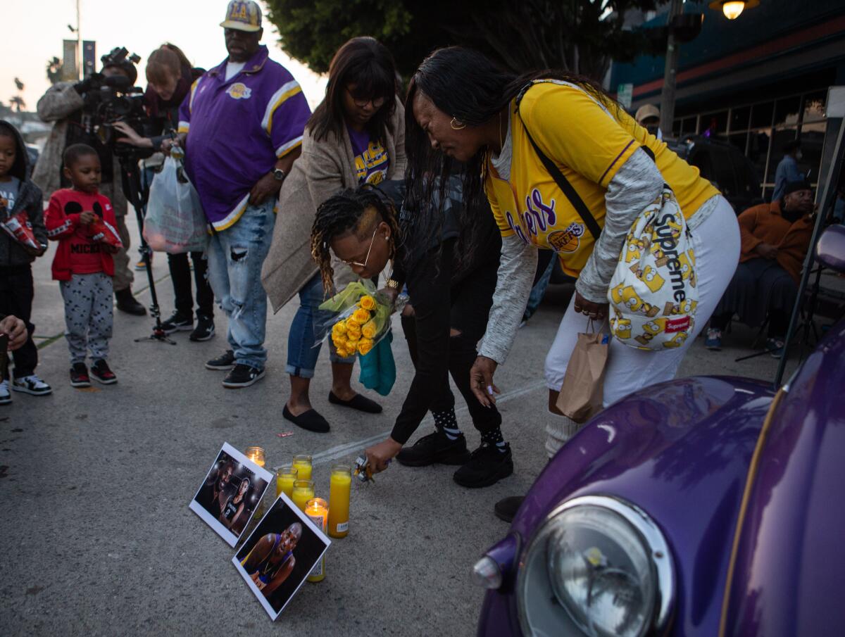 Naima Smith lays flowers and mourns the loss of Kobe Bryant on Sunday at a vigil in Los Angeles.