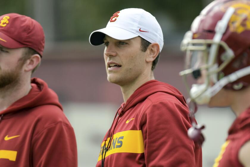In this Tuesday, March 5, 2019 photo, provided by University of Southern California Athletics, new USC offensive coordinator Graham Harrell, center, watches during NCAA college football practice in Los Angeles. Harrell stepped into one of the highest-profile assistant jobs in college football after Kliff Kingsbury left USC without calling a play. The Trojans' new offensive coordinator is working hard to get up to speed in spring practice. (John McGillen/USC Athletics via AP)