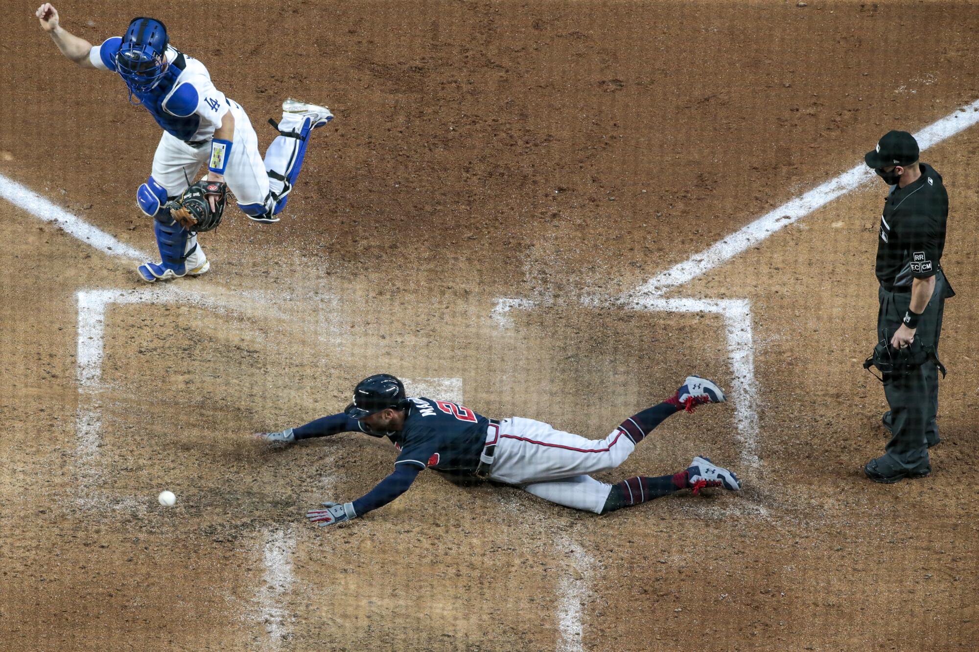 The Braves' Nick Markakis slides past Dodgers catcher Will Smith in Game 2 of the 2020 NLCS 