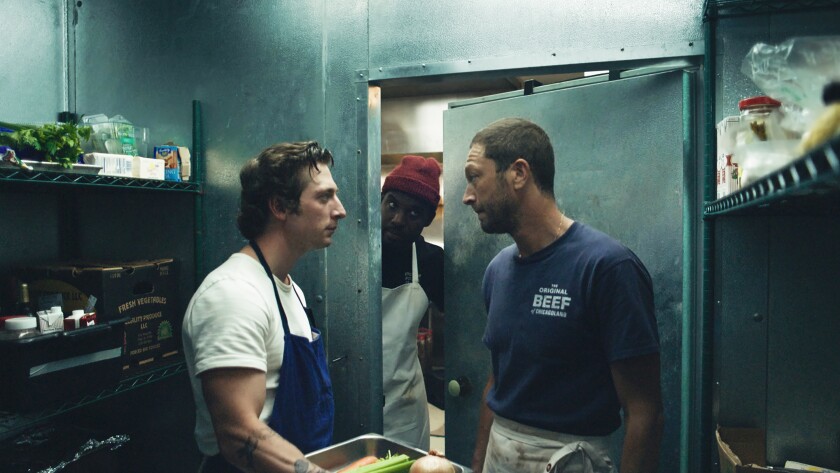 Two men in a restaurant cold storage locker, with a third man peering in through the door