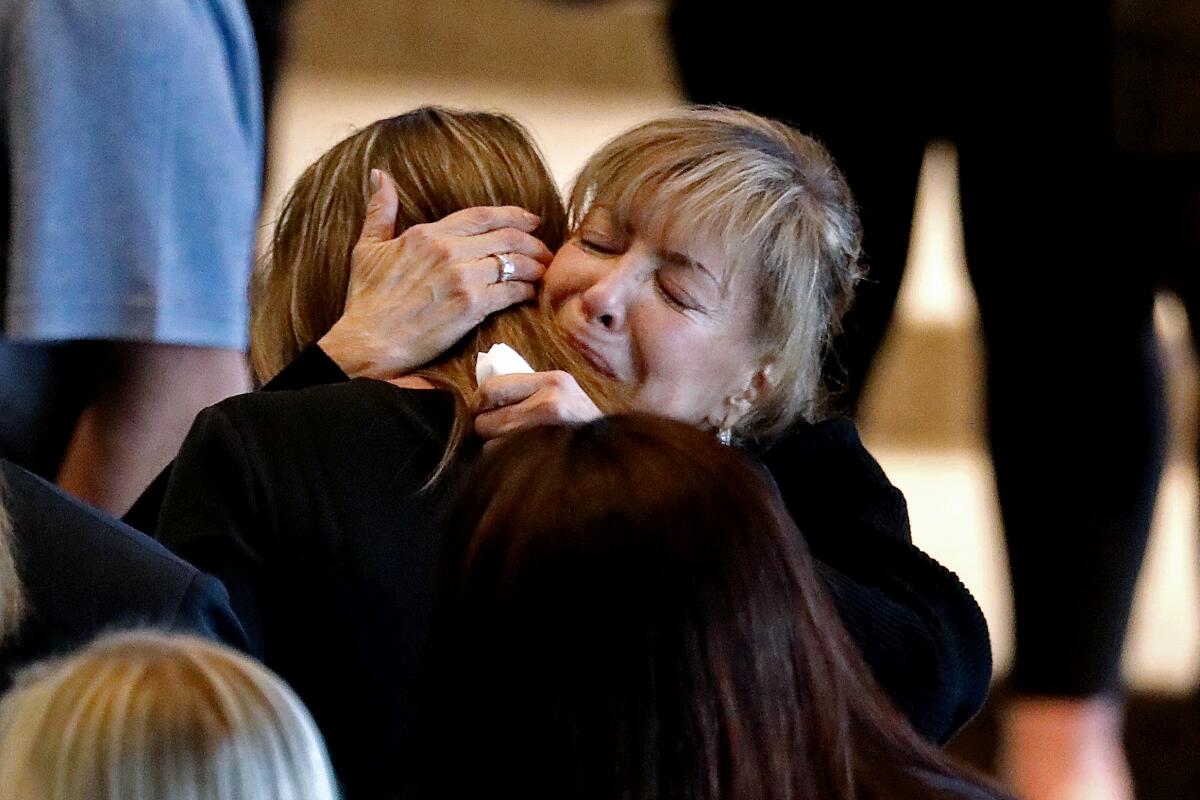 Stella Blair, right, mother of Elliot Blair, is consoled during a memorial service