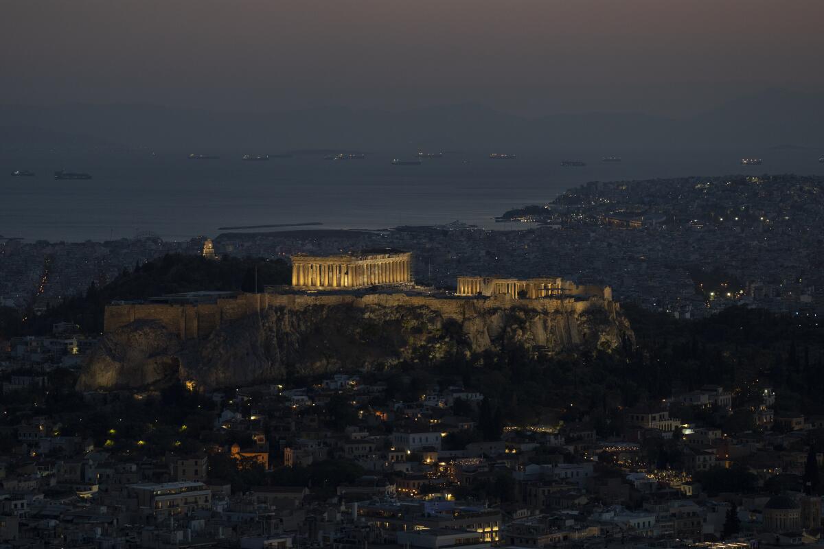 A general view of the city of Athens with the lighted ancient Acropolis hill on Wednesday , Aug. 10 , 2022.The European Union's budget watchdog announced Wednesday that it is winding up years of surveillance of Greek government spending. The move marks a formal end to a major crisis that threatened to see Greece ejected from the euro single currency group, imposed severe hardship on its citizens and roiled global financial markets. (AP Photo/Petros Giannakouris)
