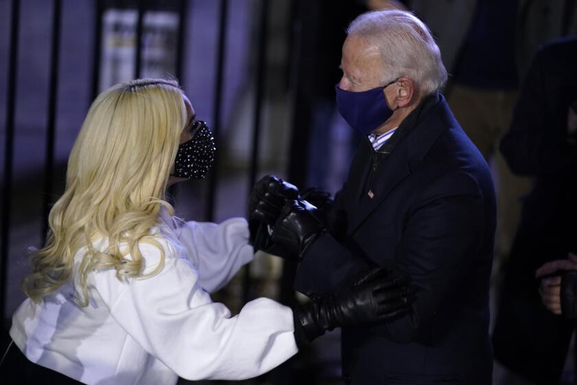 Democratic presidential candidate former Vice President Joe Biden talks with Lady Gaga during a drive-in rally at Heinz Field, Monday, Nov. 2, 2020, in Pittsburgh. (AP Photo/Andrew Harnik)
