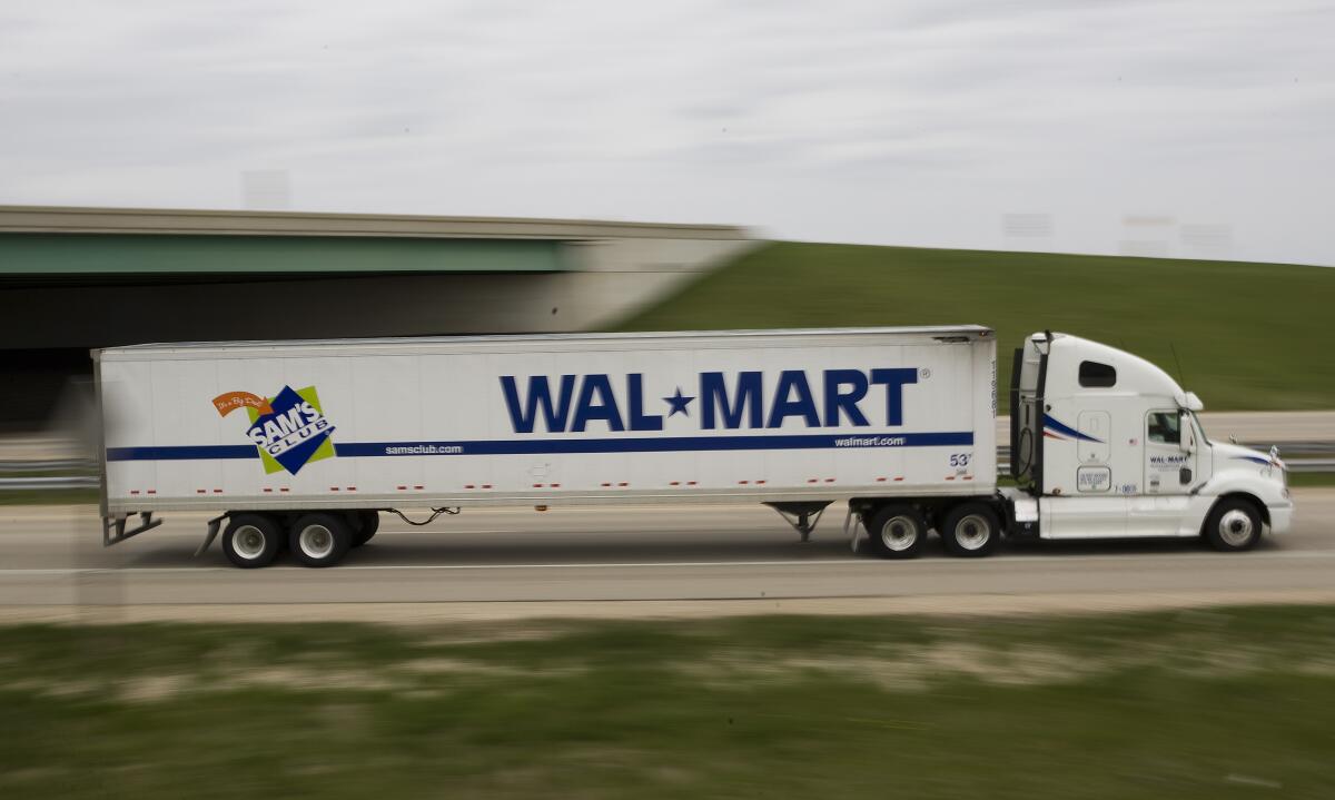 A Walmart truck travels on a highway.