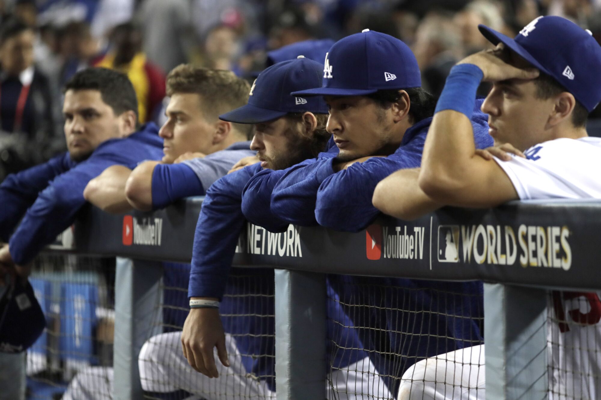 Austin Barnes, Yu Darvish, Clayton Kershaw and Enrique Hernandez watch the Astros celebrate on the field from their dugout