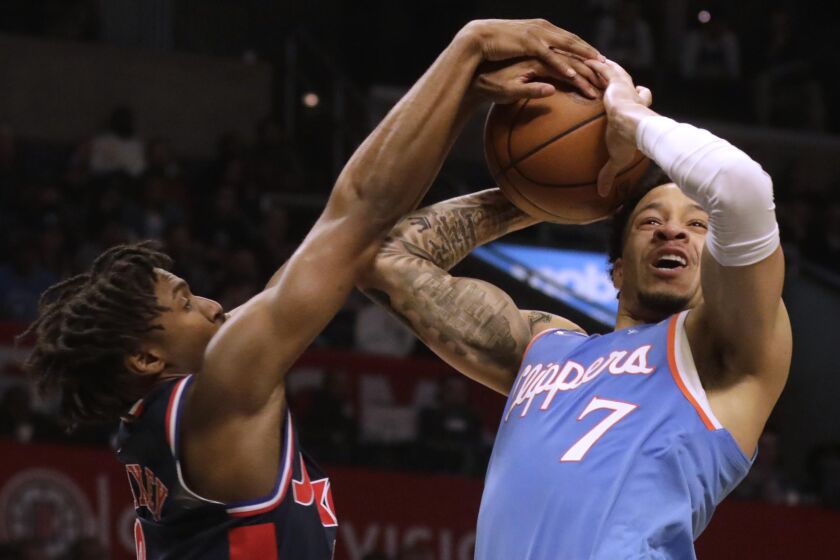 LOS ANGELES, CA - MARCH 25, 2022 - - LA Clippers Amir Coffey fights for control of the ball against Philadelphia 76ers Tyrese Maxey at Crypto.com Arena in Los Angeles on March 25, 2022. (Genaro Molina / Los Angeles Times)