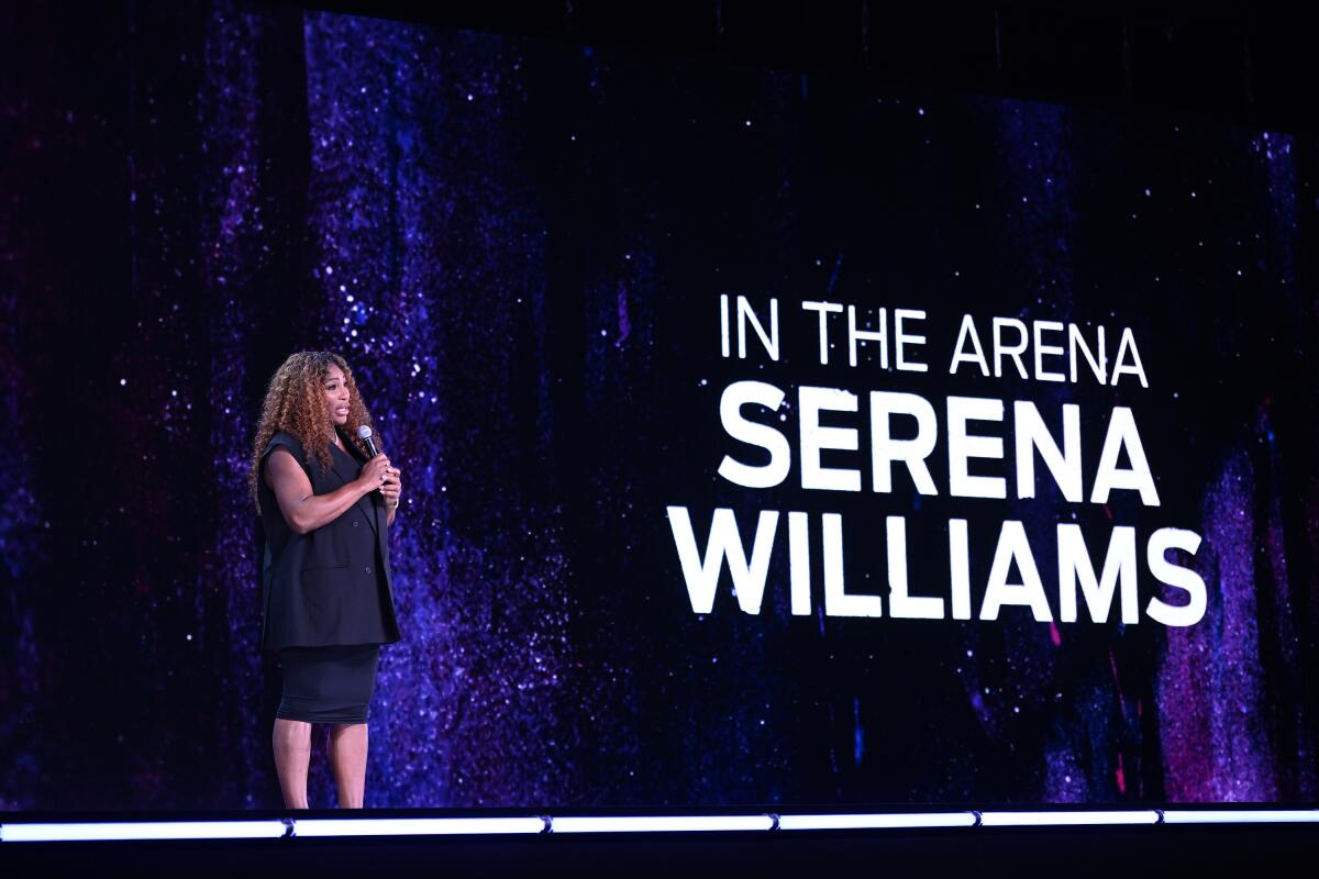 woman with a mic with words "In the arena Serena Williams" behind her 