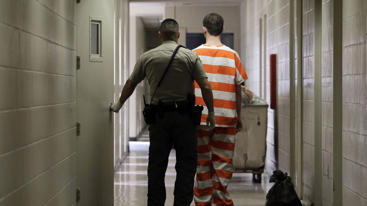 In this Feb. 21, 2013, file photo, an inmate at the Madera County Jail is taken to a housing unit at the facility in Madera, Calif.