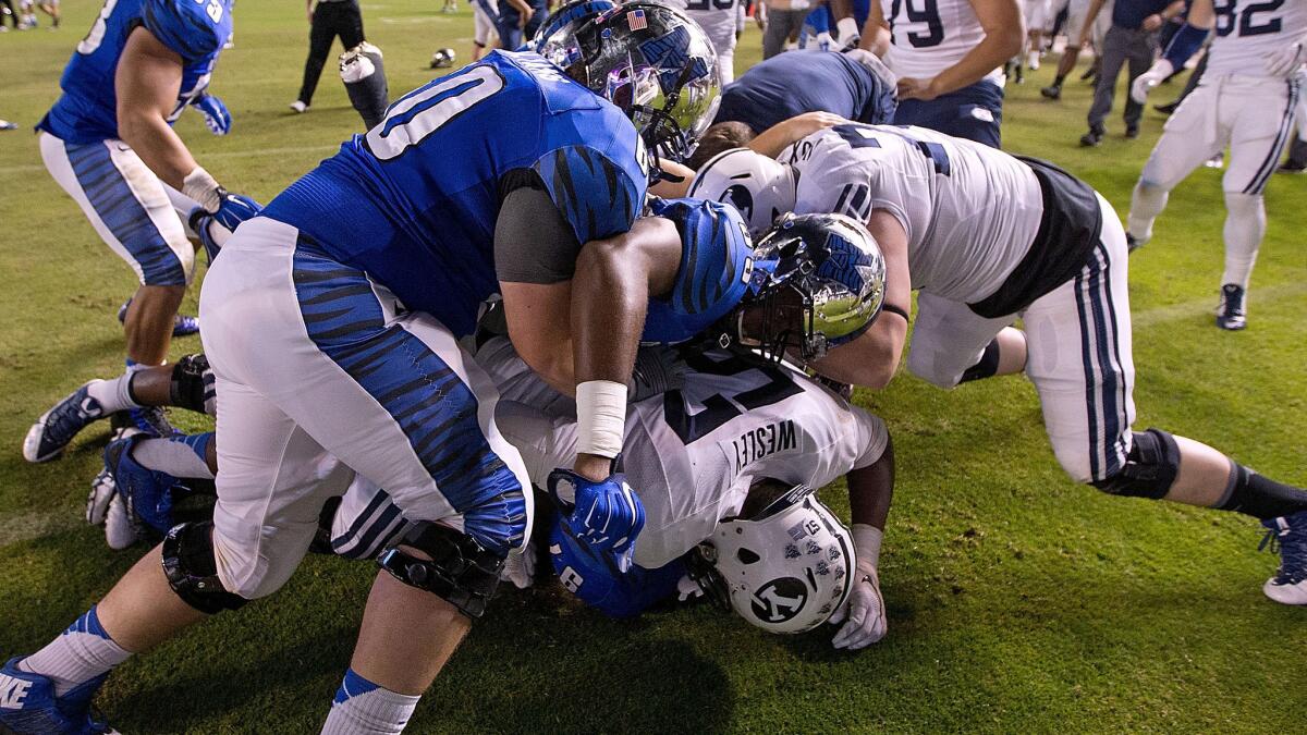 Players fight on the field following Memphis' double-overtime win over Brigham Young in the Miami Beach Bowl on Monday.