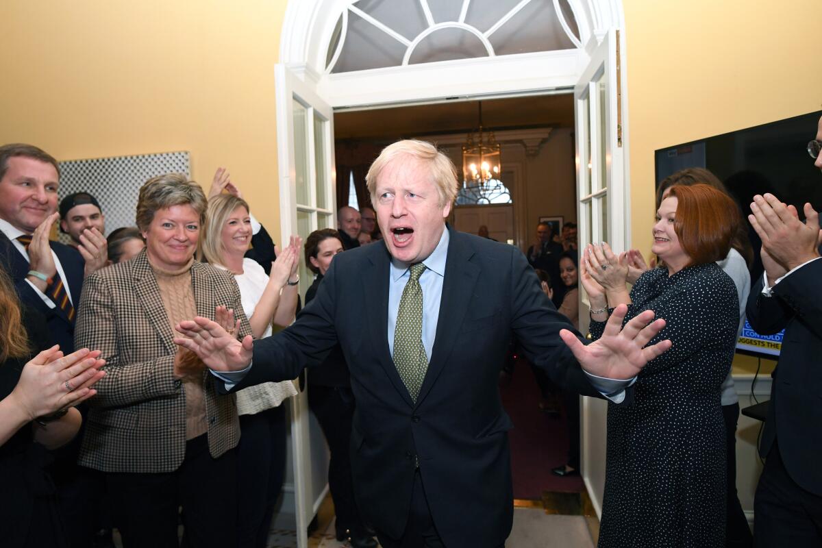 British Prime Minister Boris Johnson leaves Conservative Party headquarters in London on Dec. 13 with his partner, Carrie Symonds, and their dog, Dilyn.