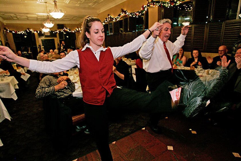 Owner John Papadakis dances with daughter Angeliki at the restaurant, which is a lot like its owner -- big, brash and loud.