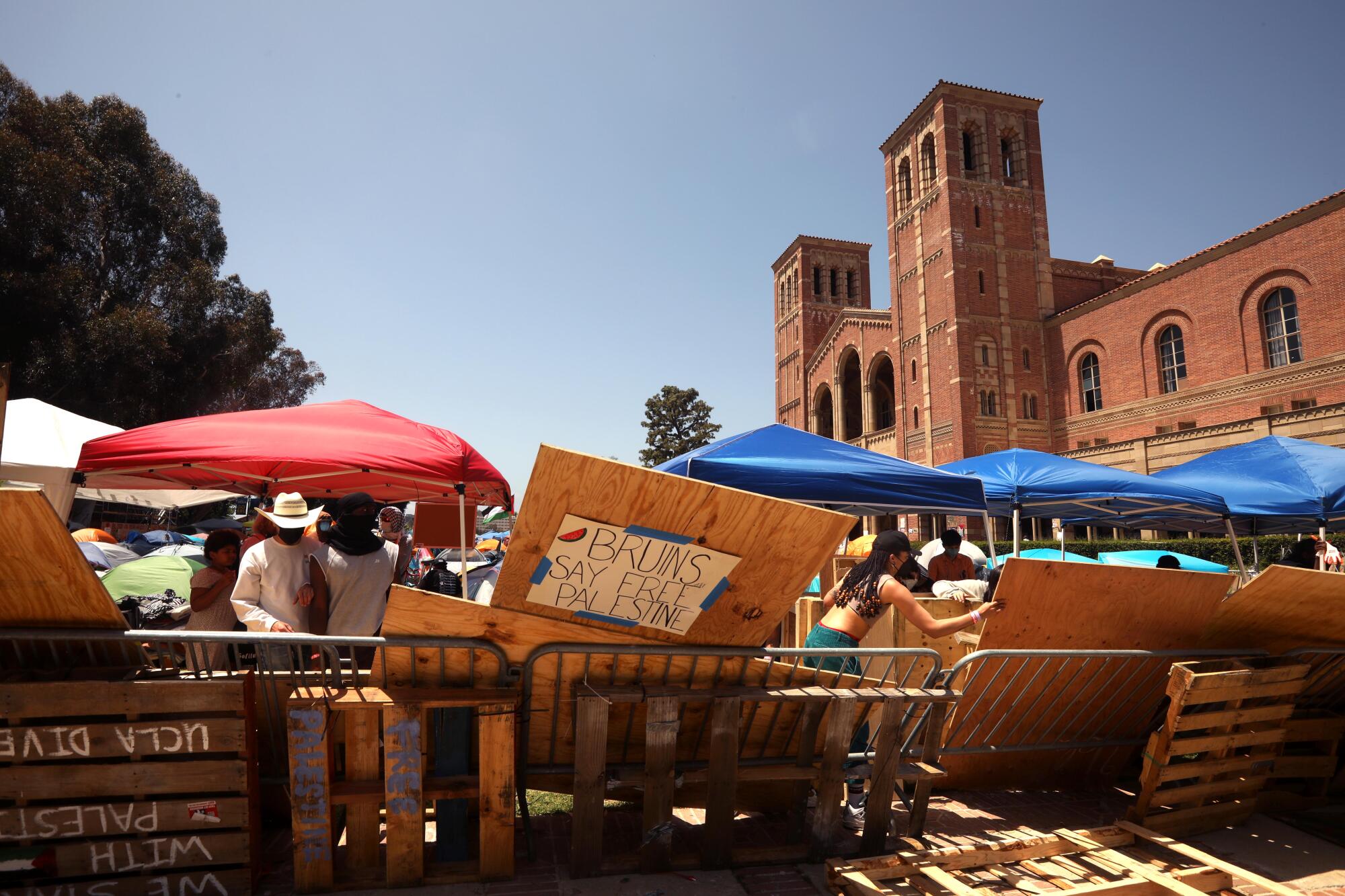 Protesters brace up the fence around the pro-Palestinian camp on the UCLA campus on May 1, 2024. 