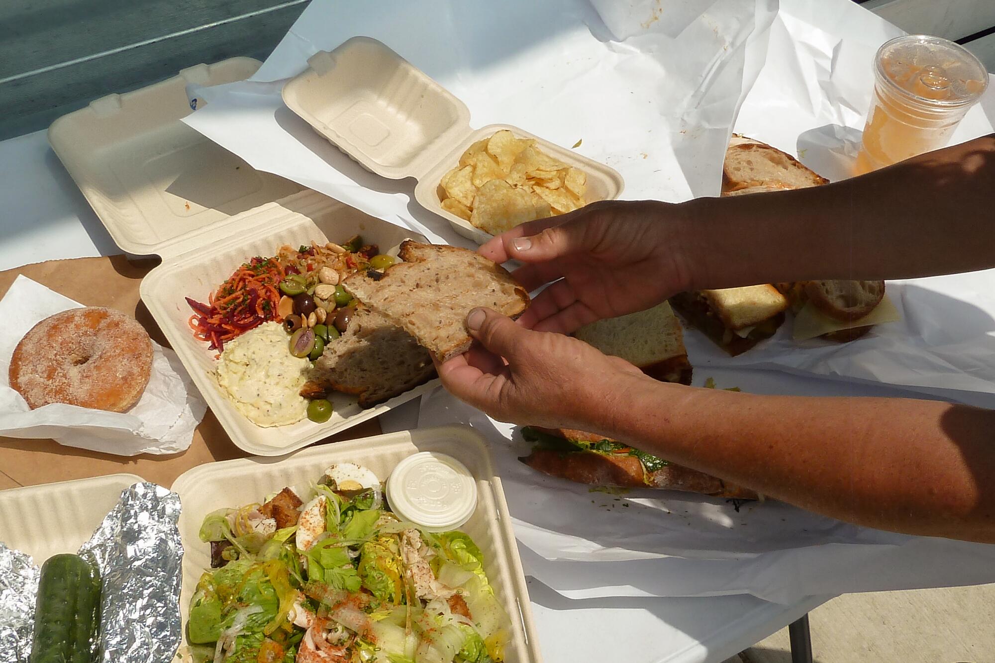 Takeaway containers hold bread and salads.