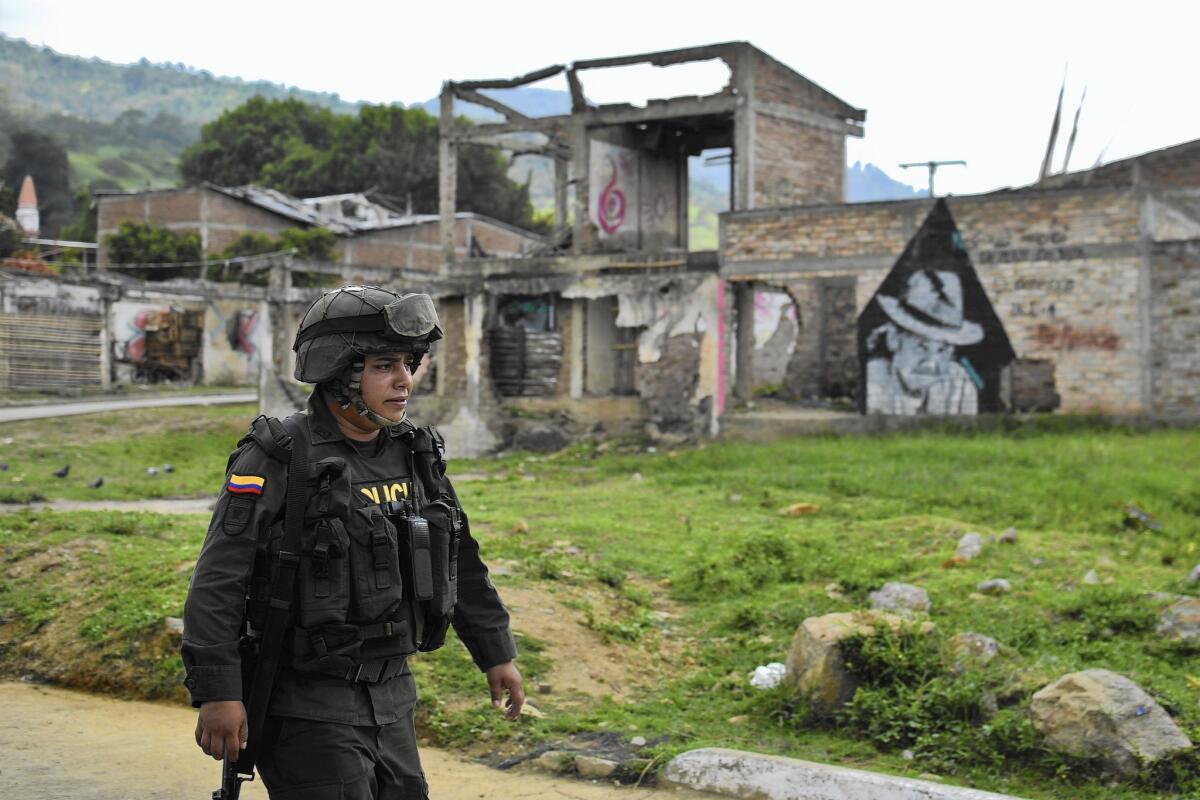 A Colombian police officer patrols a street in Toribio.