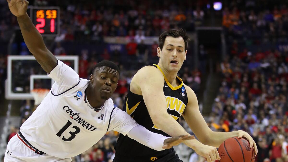 Cincinnati's Tre Scott battles for the ball with Iowa's Ryan Kriener during the first round of the NCAA tournament March 22 in Columbus.