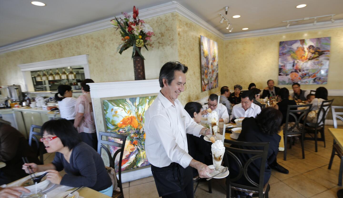 Roberto Torres, an employee of 25 years, serves desserts at hotspot Song Long Restaurant, which serves French and Vietnamese fusion cuisine in Westminster.