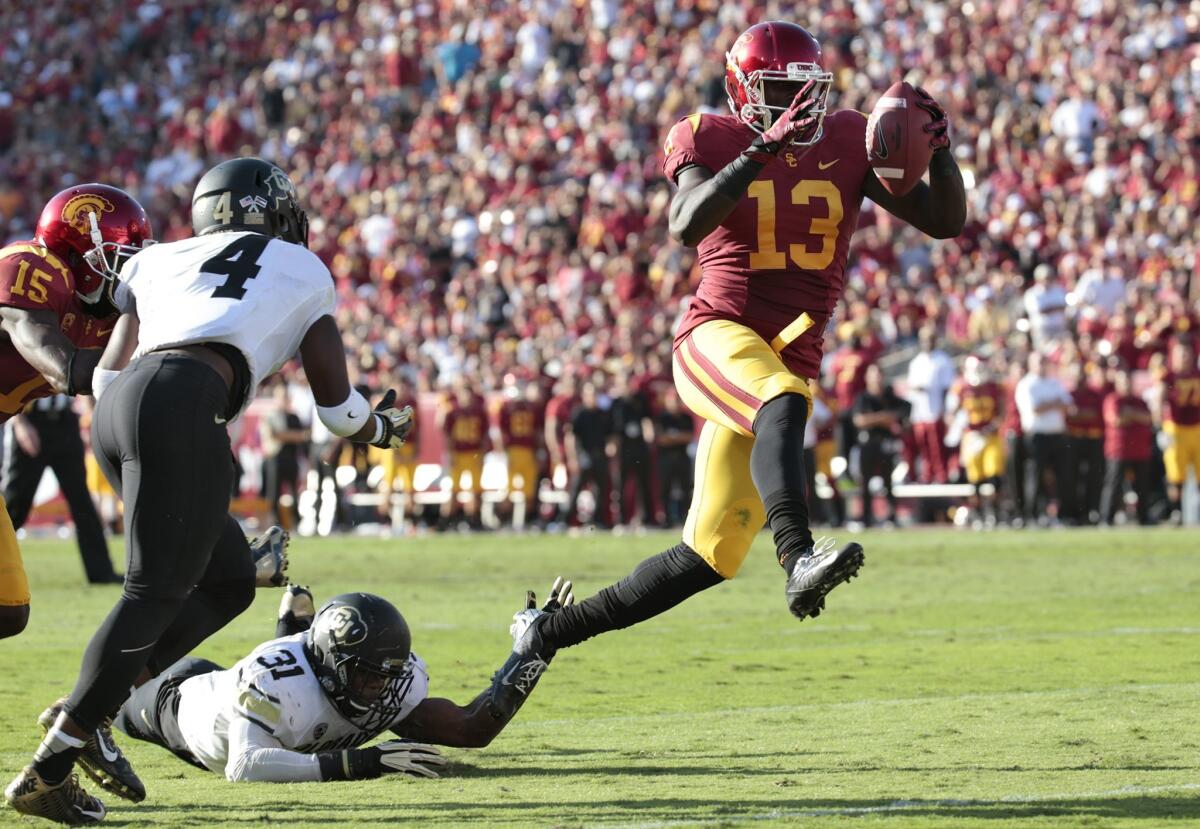 USC tight end Bryce Dixon high steps into the end zone past Colorado defensive back Kenneth Olugbode late in the second quarter Saturday at the Coliseum.