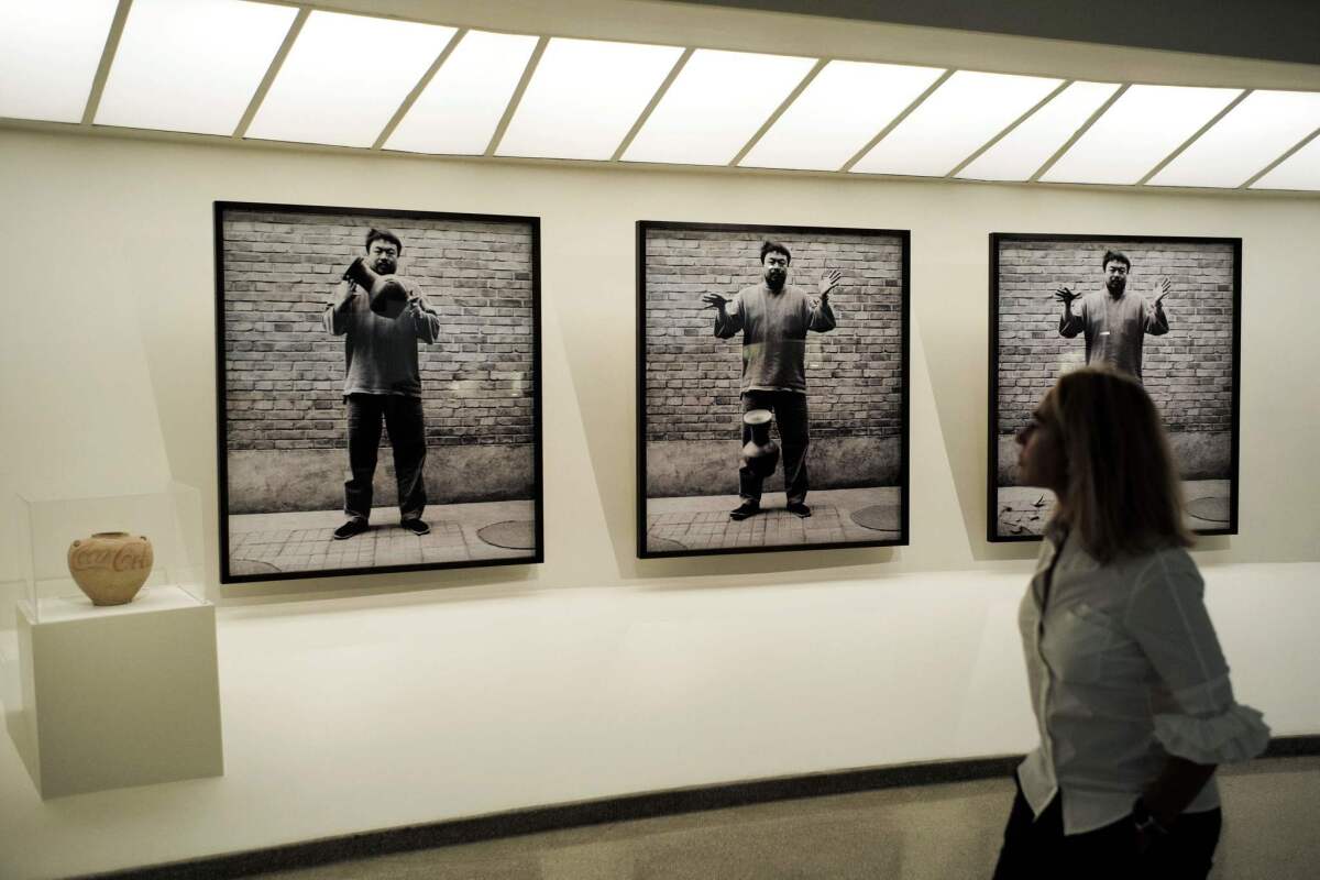 A visitor passes a series of photographs by Ai Weiwei at the Guggenheim Museum.
