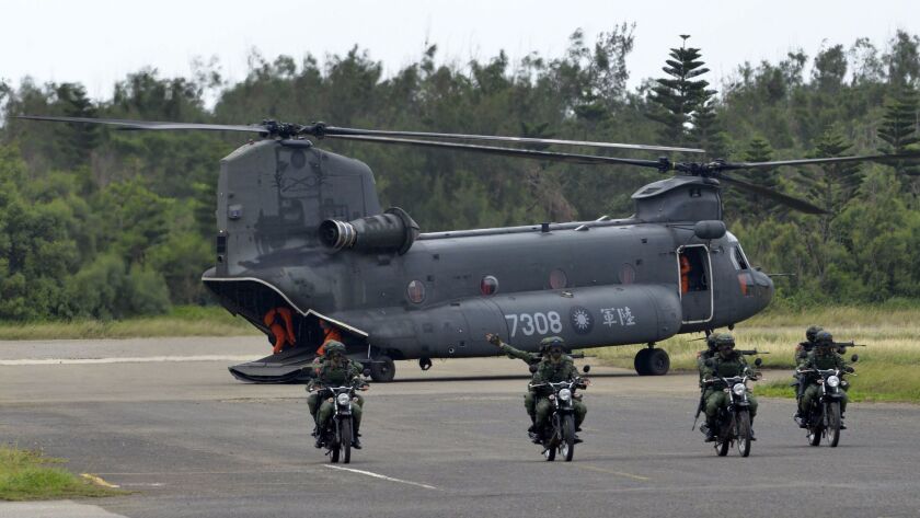 Armed Taiwanese soldiers ride on motorcycles next to a US-made CH-47 helicopter on May 25 during a live-fire drill on the outlying Penghu islands.